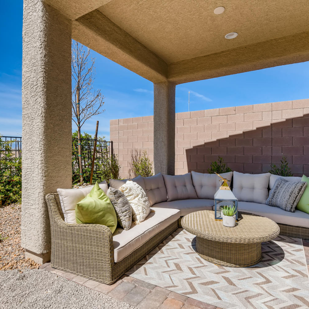 Spacious covered patio boasting a large wicker couch and charming wicker coffee table. 