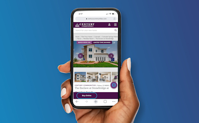 Hand holding up a cell phone showing homes available to buy online