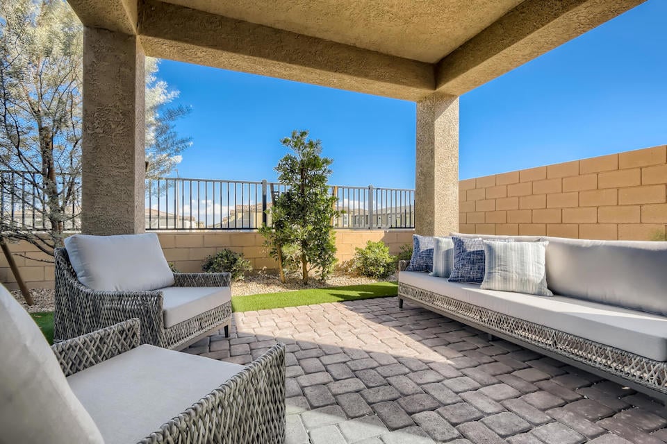 A patio with a couch and a table and chairs.