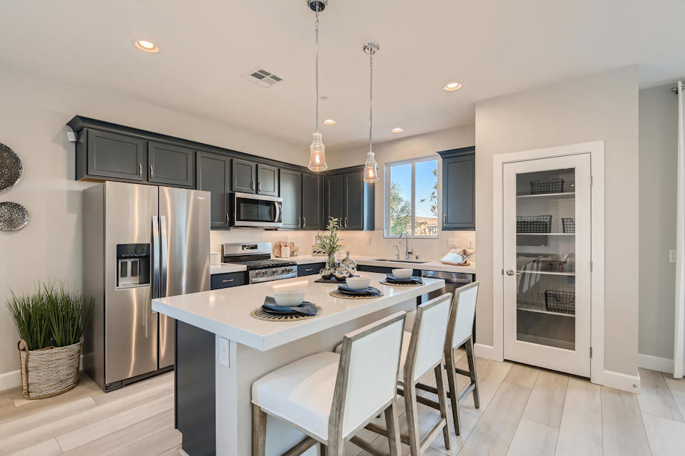 A kitchen with a white table and chairs.