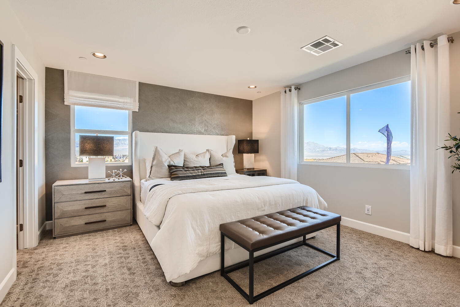 A bedroom with a large window.