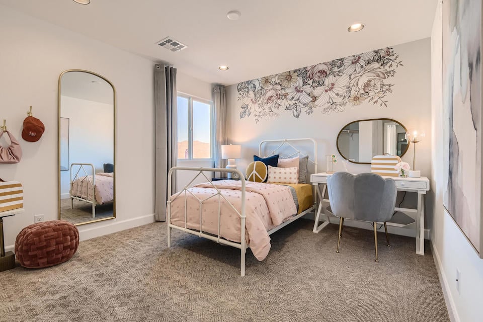 A bedroom with a bed and a mirror.