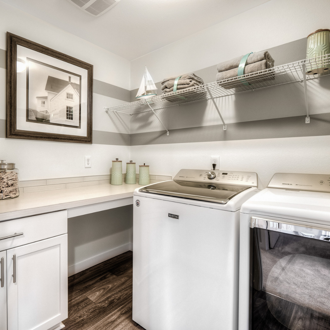 Stunning laundry room with pristine washer and dryer, shelf space and storage. 