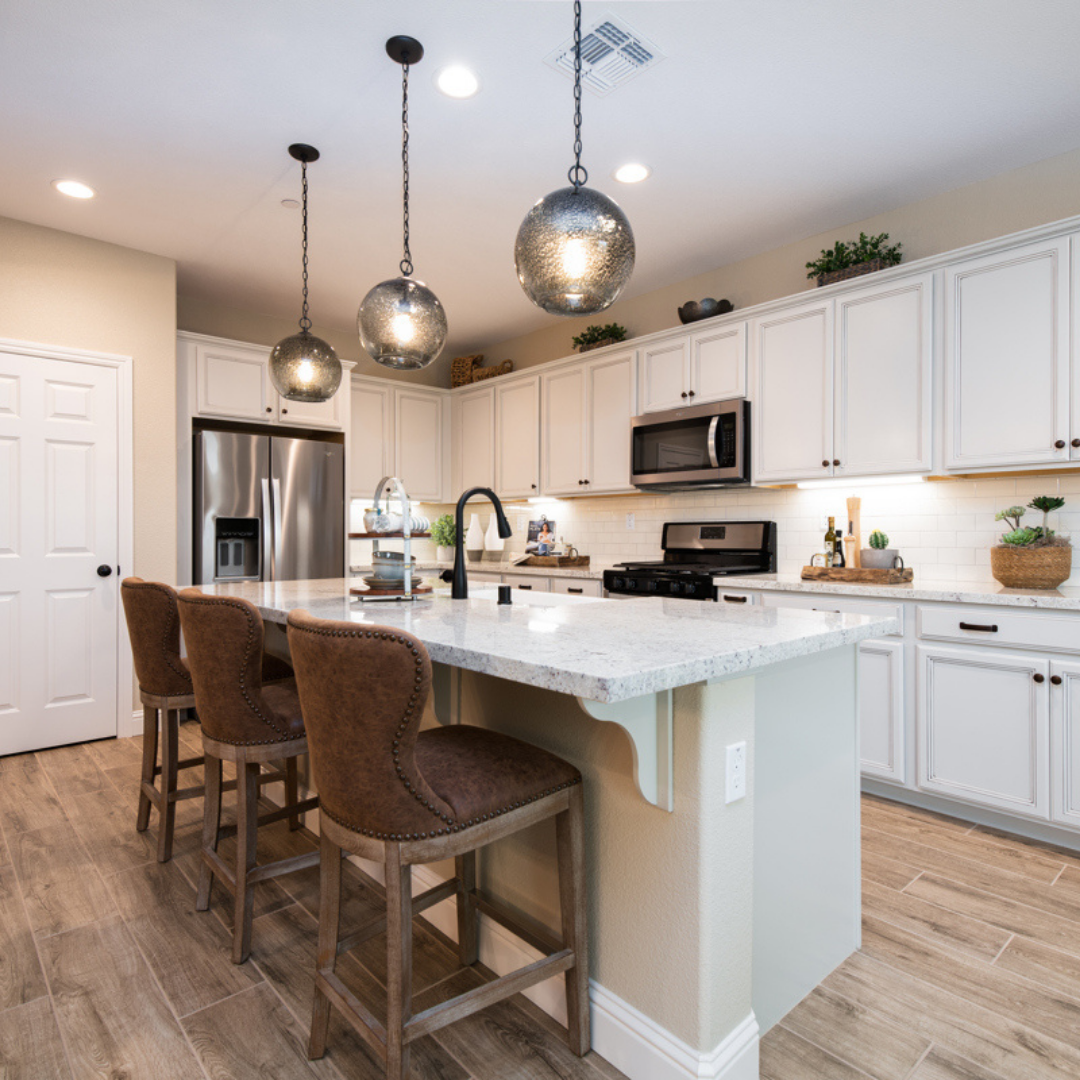 Stunning kitchen with white cabinets, white granite counters and stainless-steel appliances.