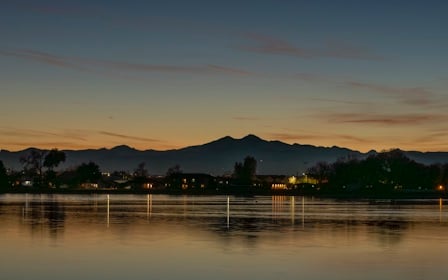 A body of water with trees and mountains in the background.