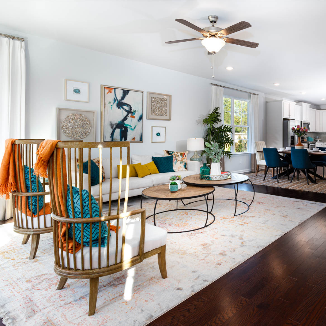 Spacious great room boasting colorful pillows, florals, and paintings.