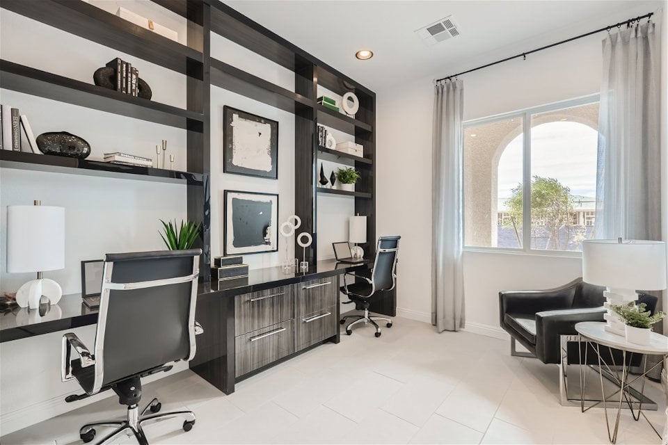 A room with a desk and chairs.