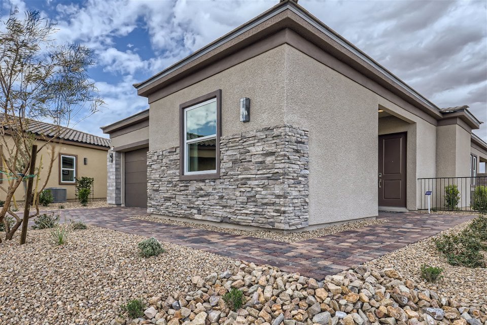 A stone house with a stone driveway.