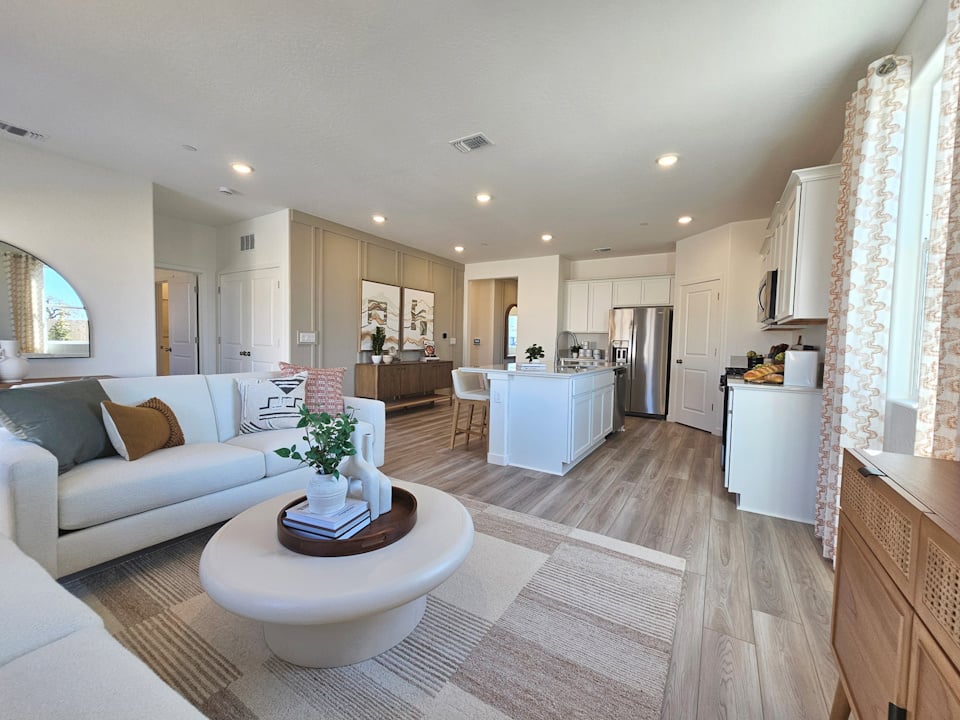 A large living room with a large white couch and a white table.