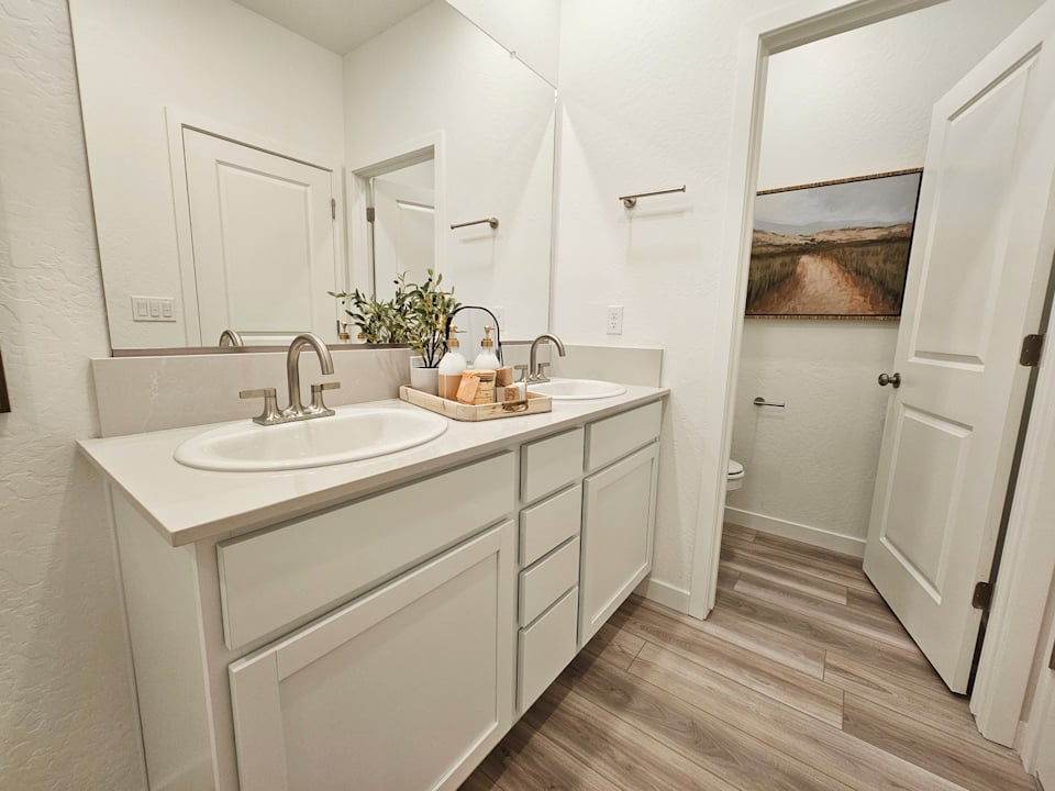 A bathroom with white cabinets.