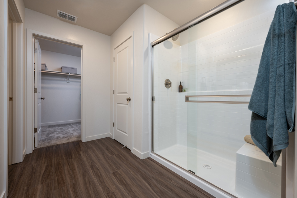 A bathroom with a shower unit and a bathtub.