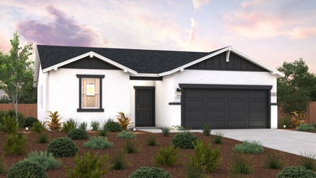 A house with a garage and bushes in front of it.