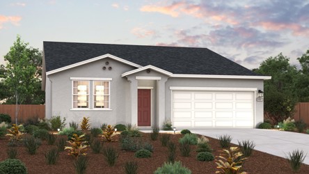 A house with a garage and bushes in front of it.