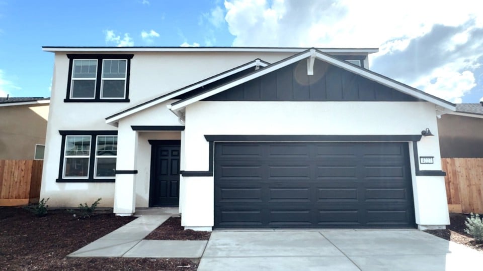 A white house with a garage.