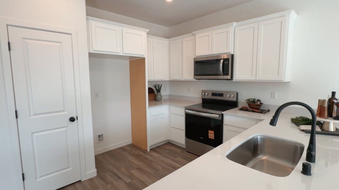 A kitchen with white cabinets.