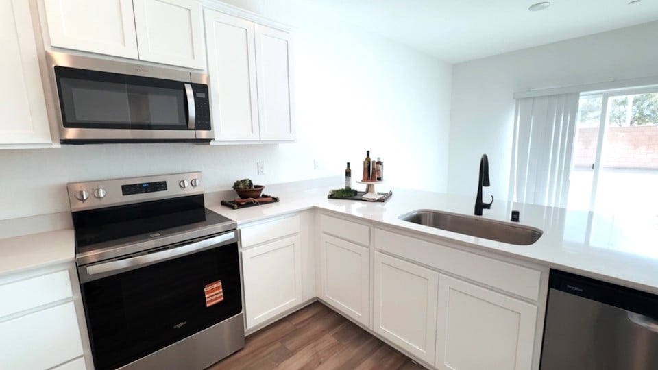 A kitchen with white cabinets.