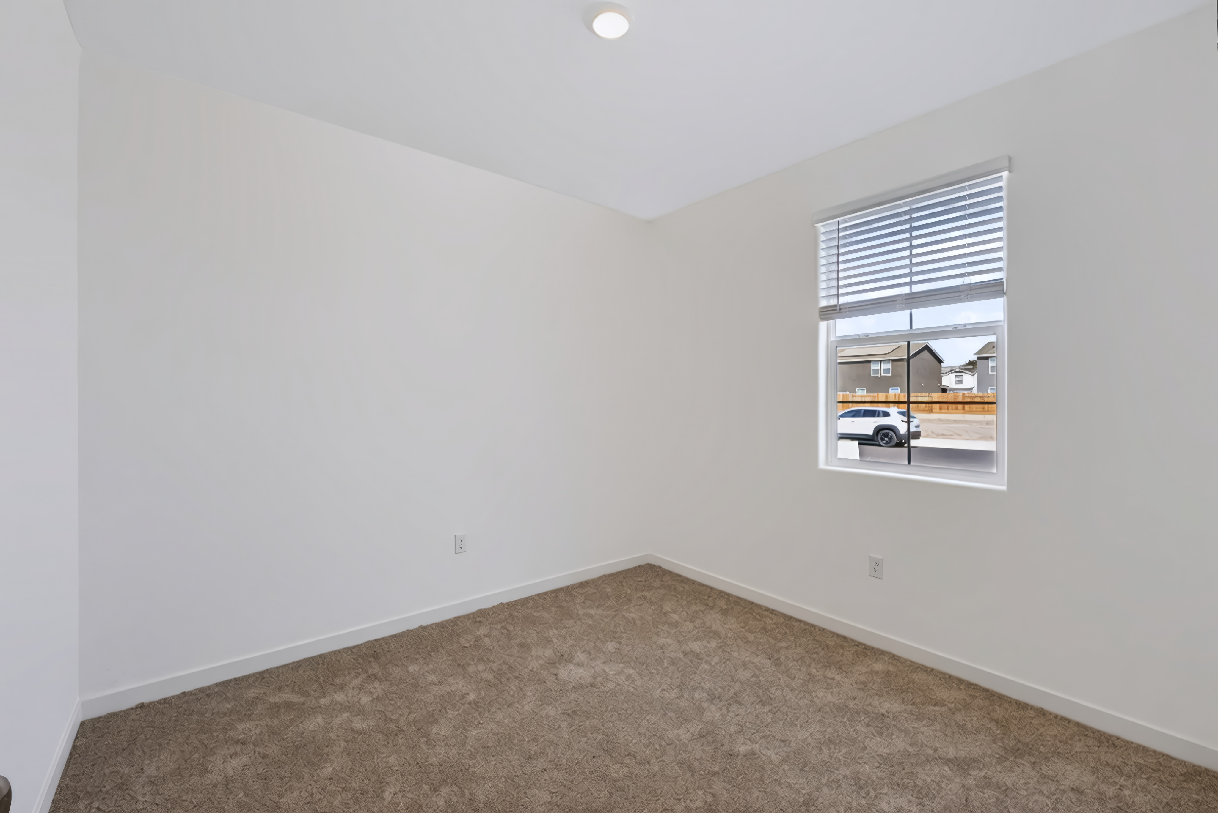 A room with a window and carpet.