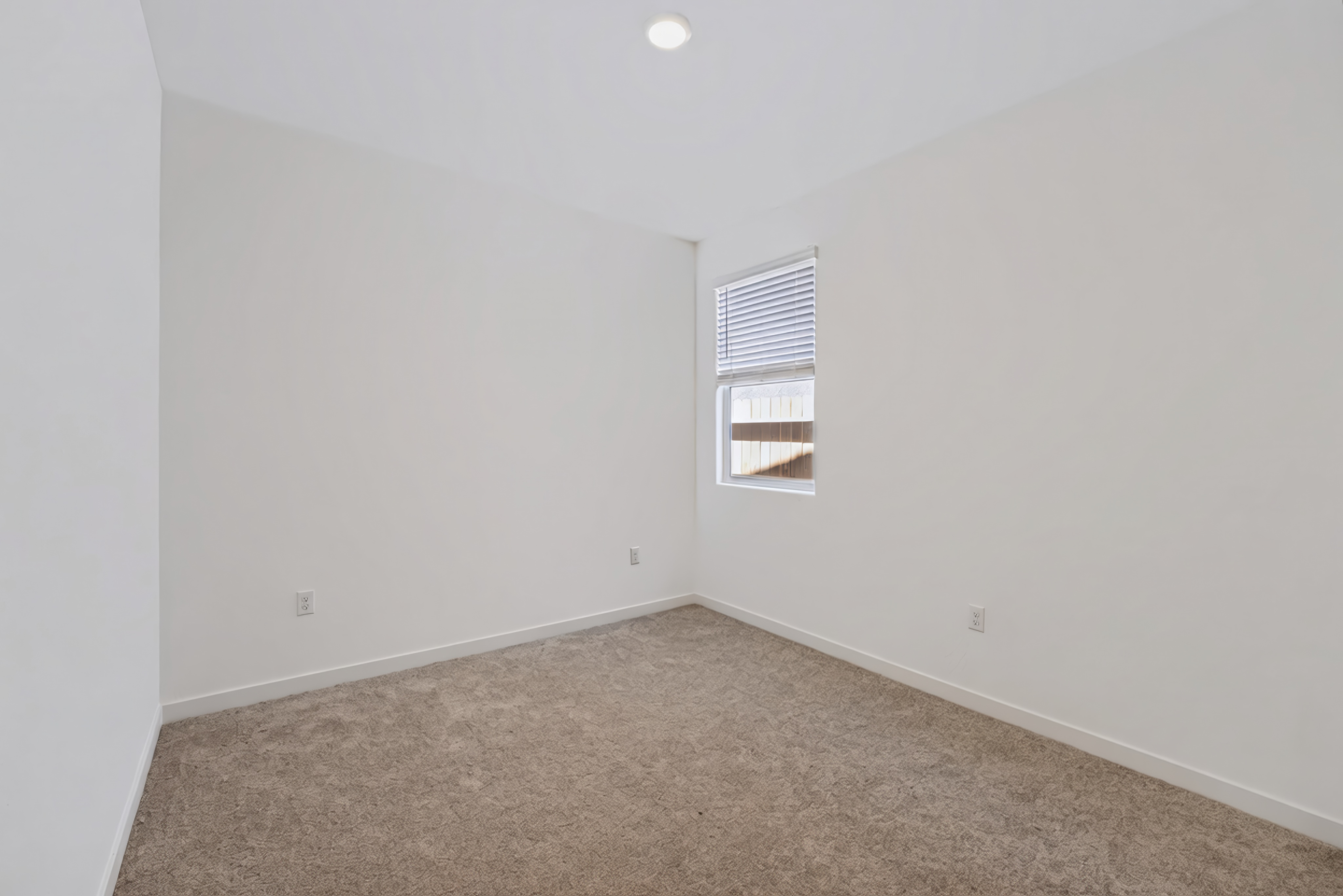 A room with a window and carpet.
