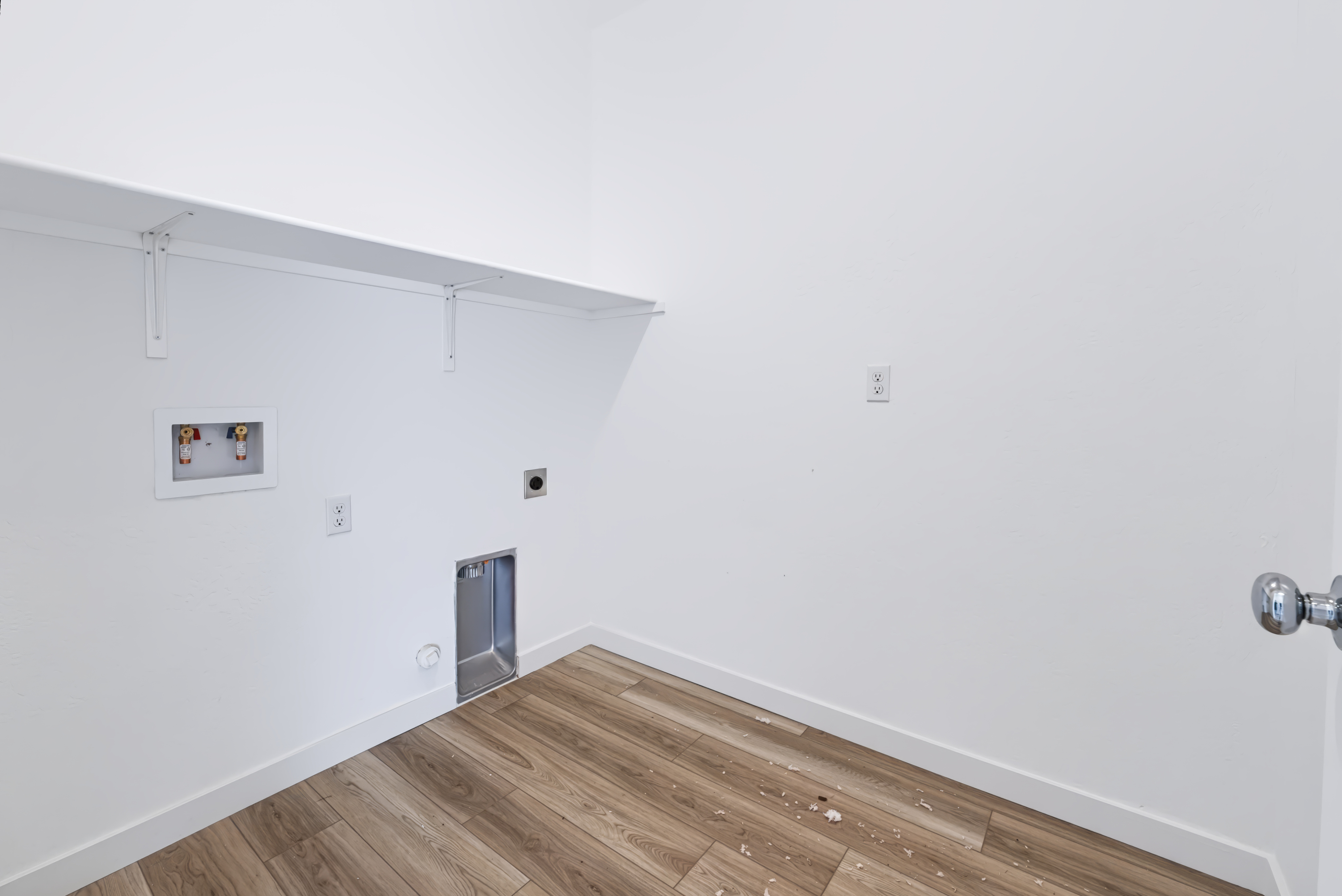 A room with a wood floor and white walls.