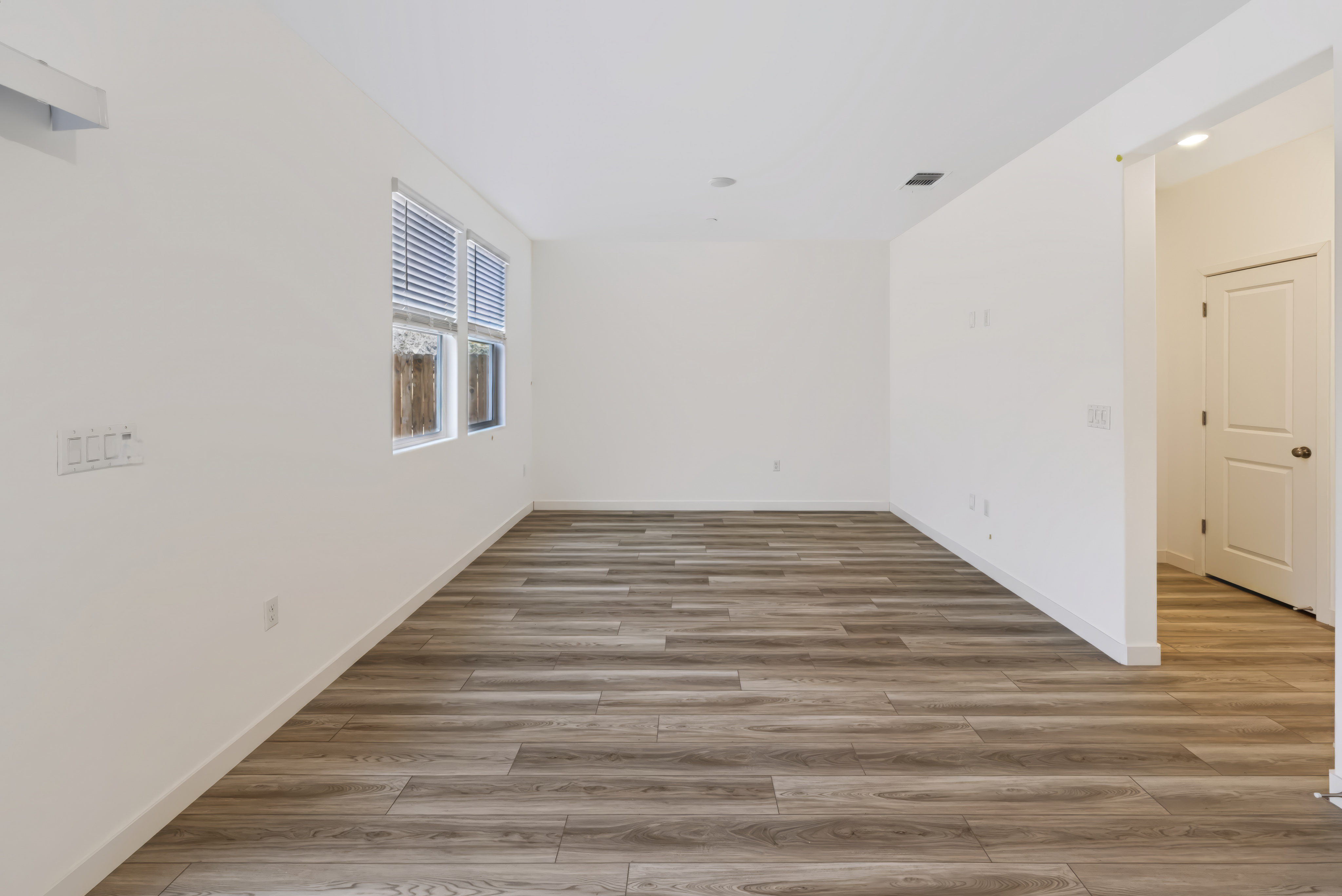 A room with white walls and wood floors.