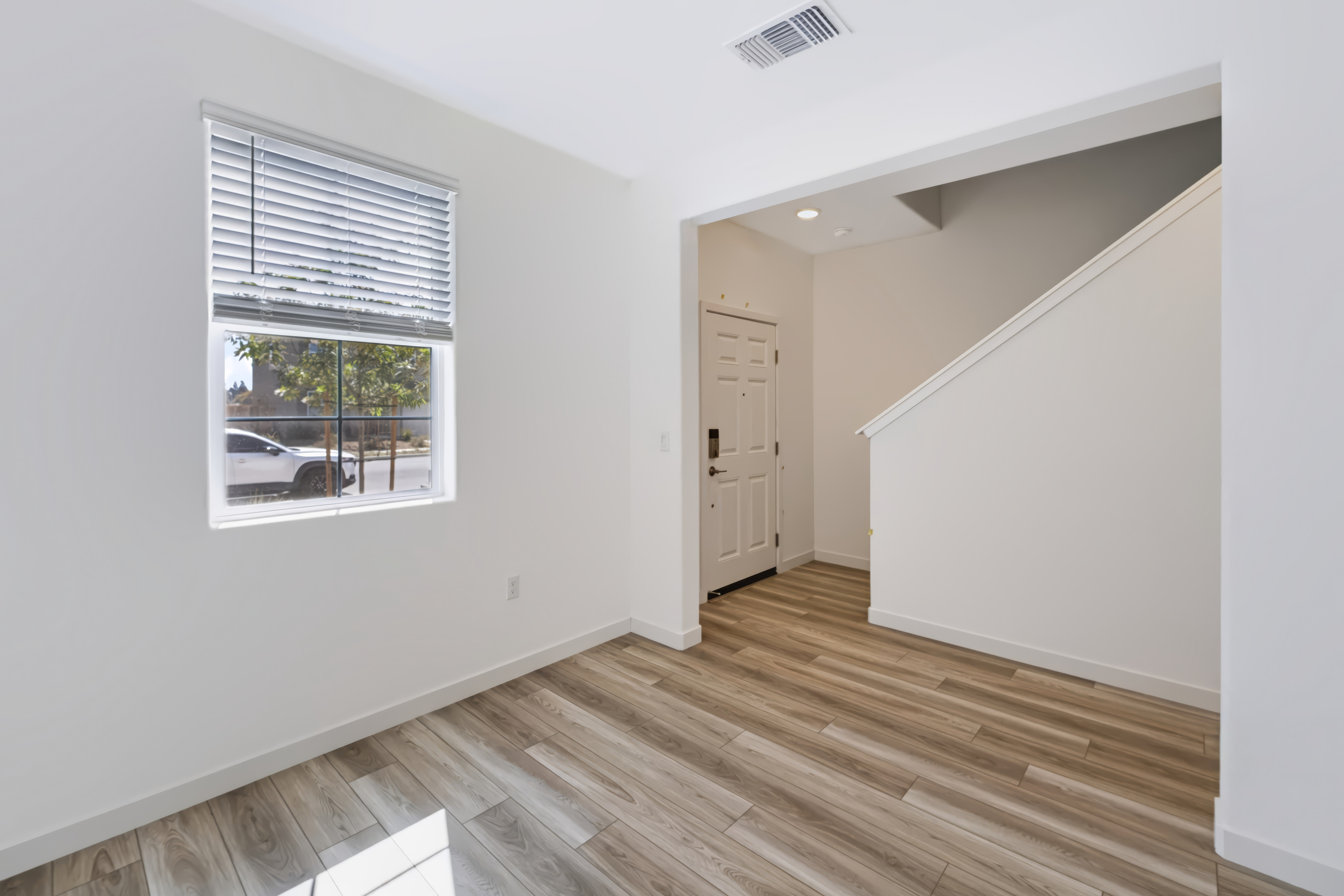 A room with a wood floor and a window.