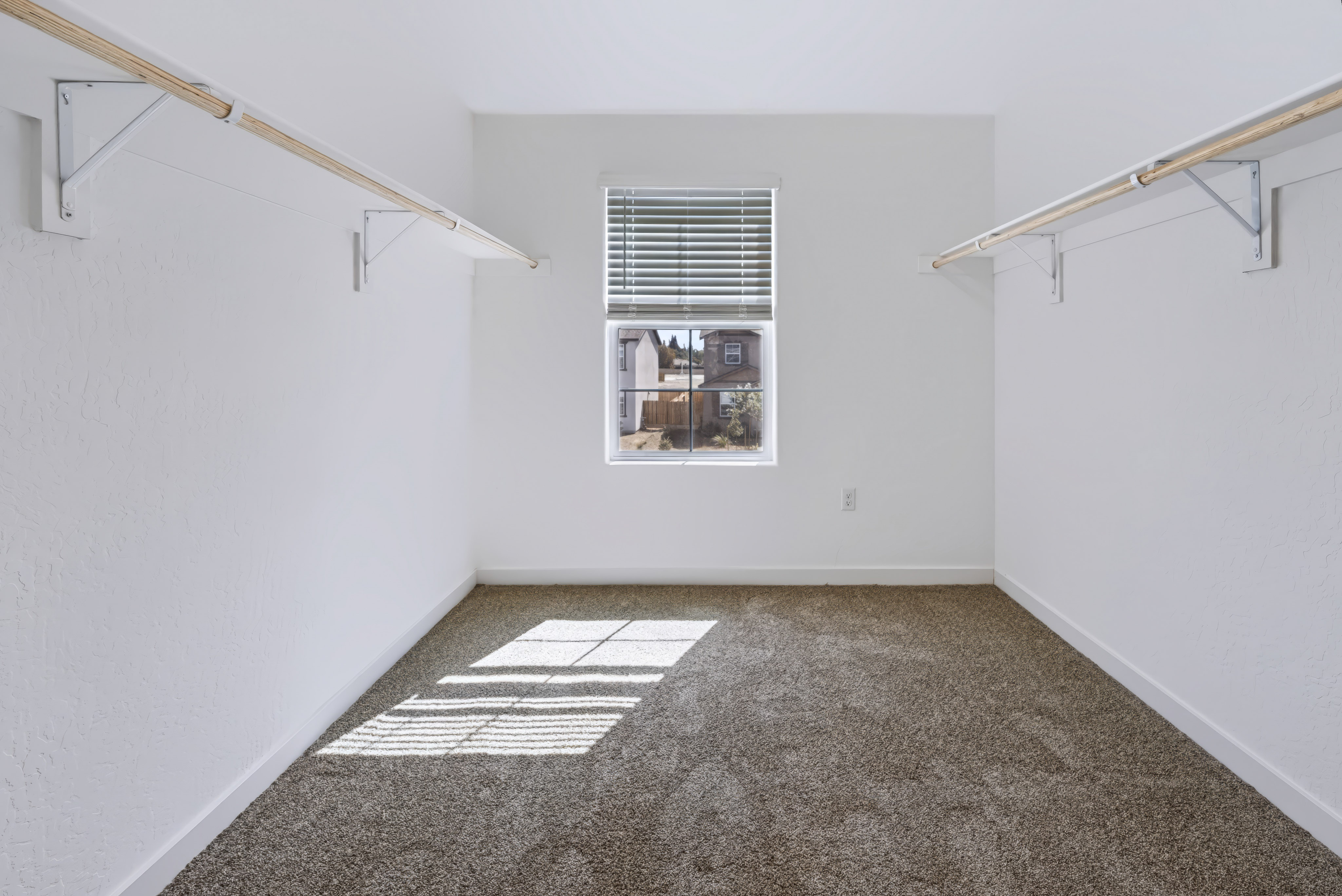 A room with a window and a rug.