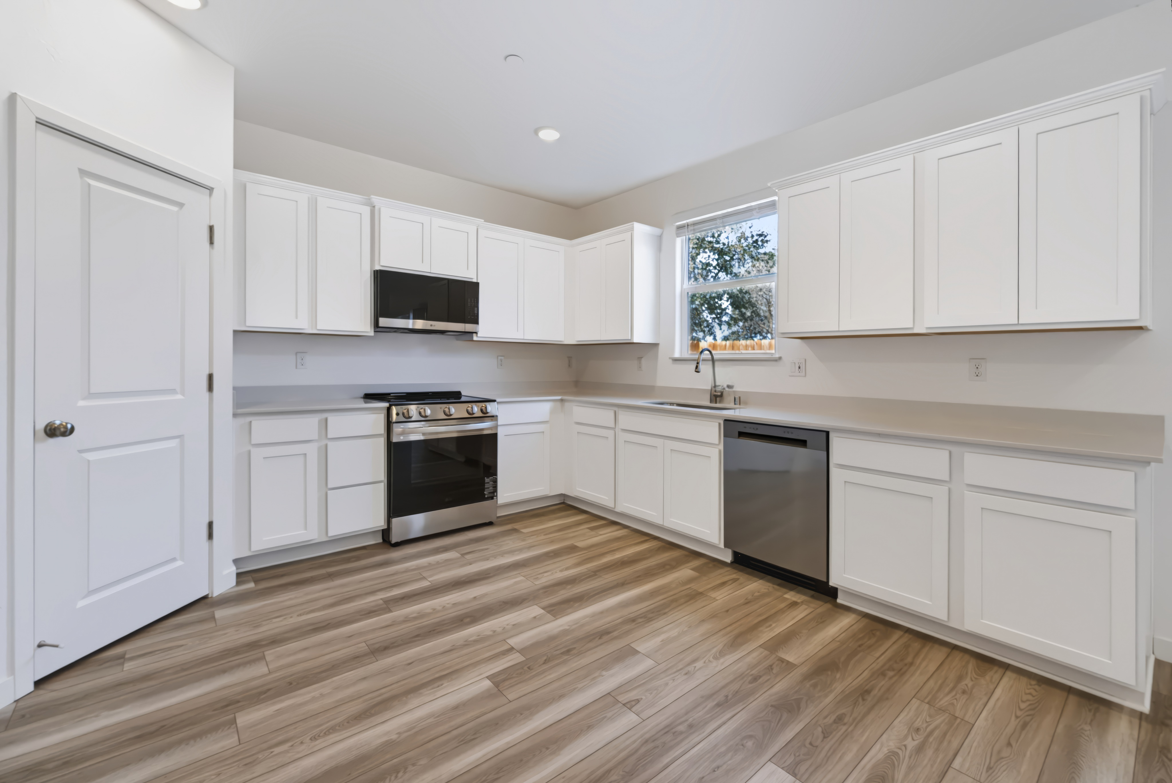 A kitchen with white cabinets.