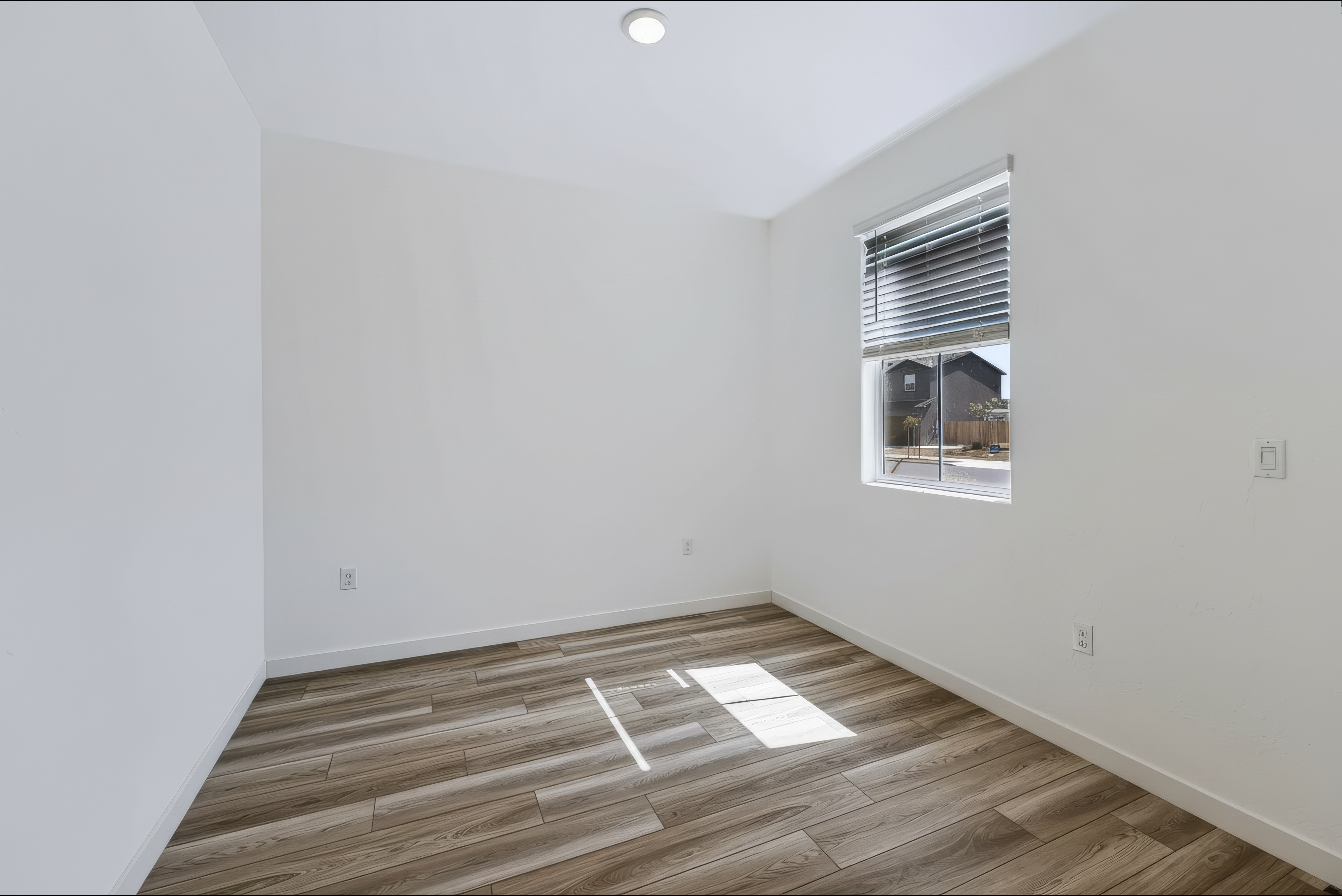 A room with a wood floor and a window.