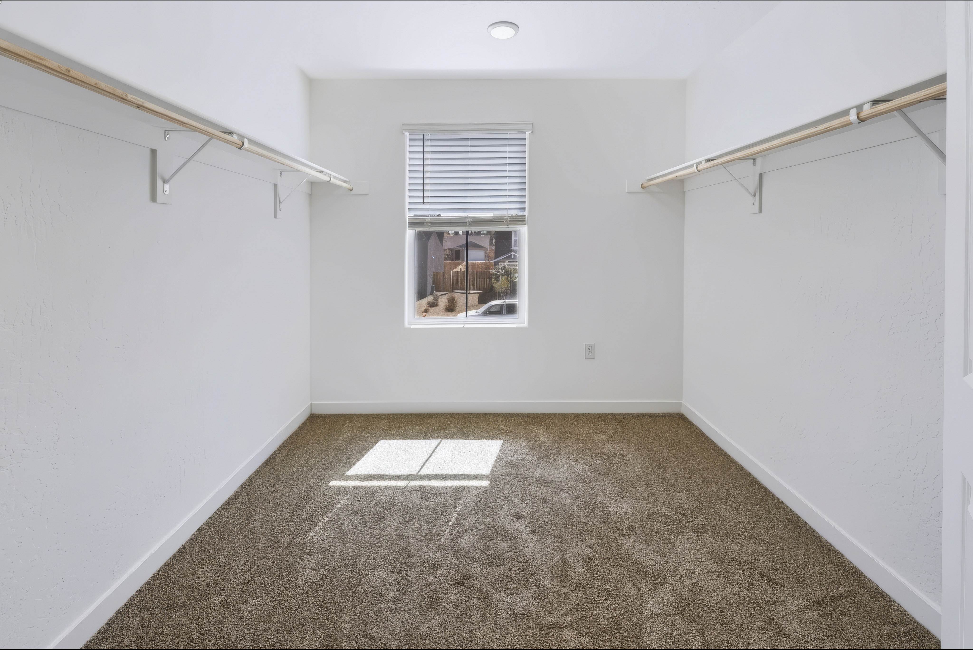 A room with a window and a rug.