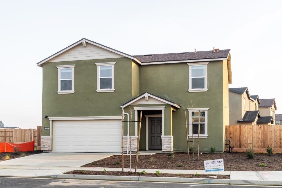 A green house with a garage.