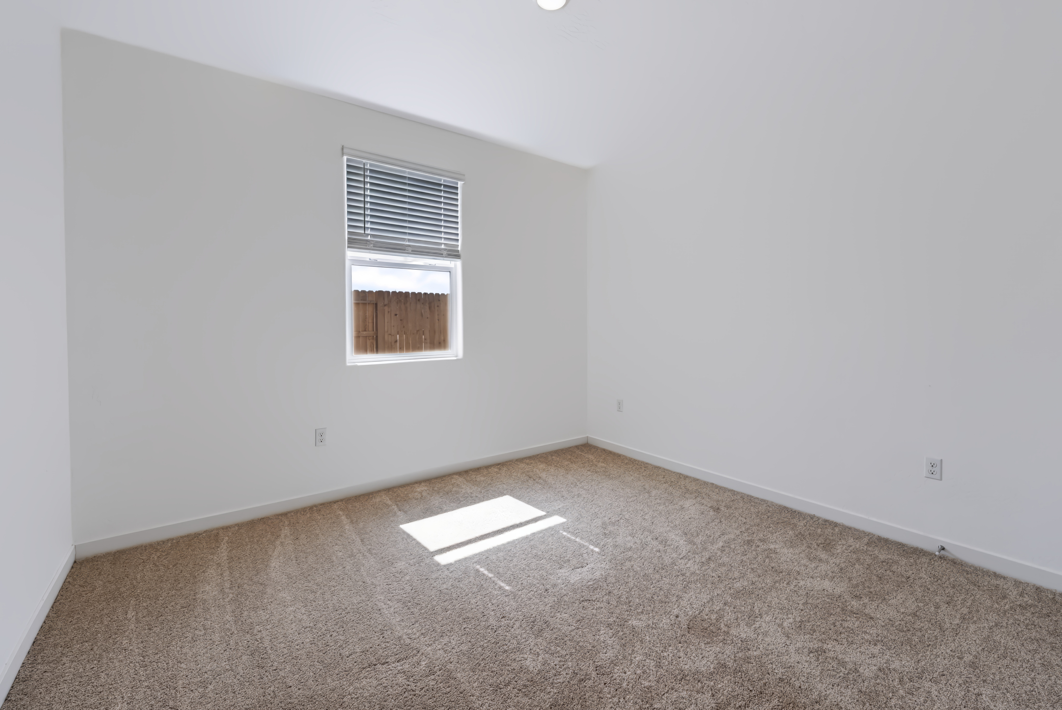 A room with a window and carpet.