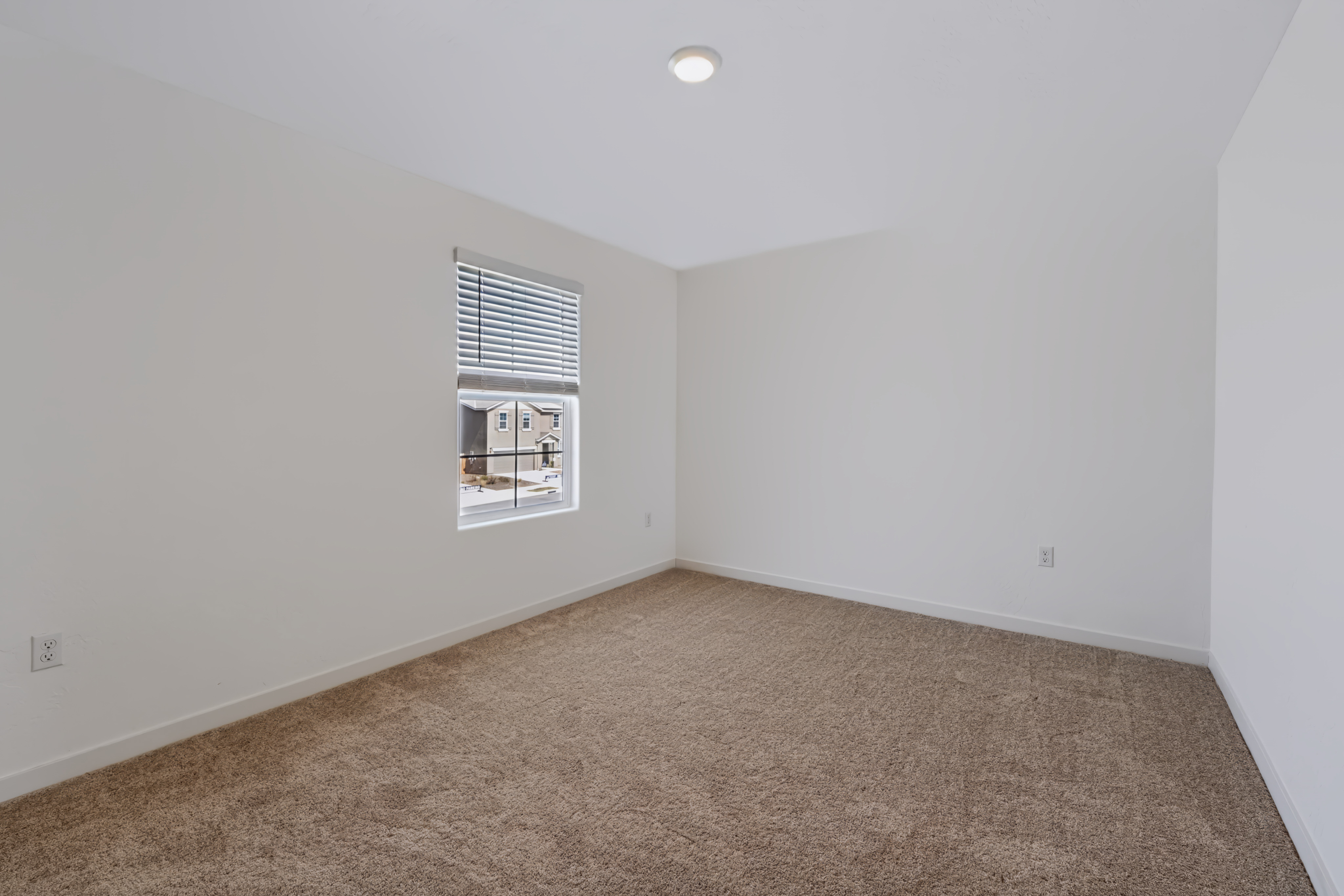 A room with a carpet and a window.