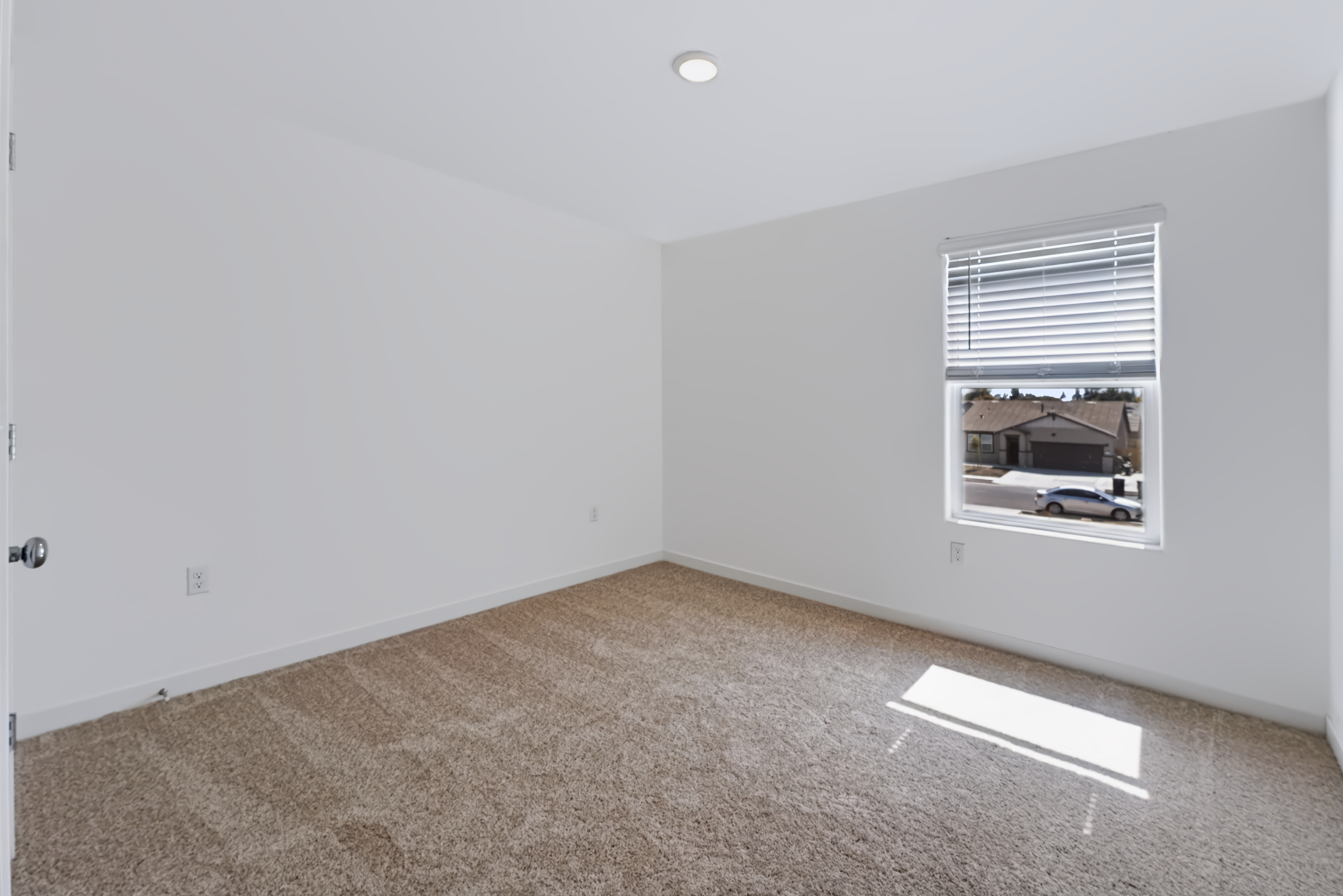 A room with a window and a carpet.