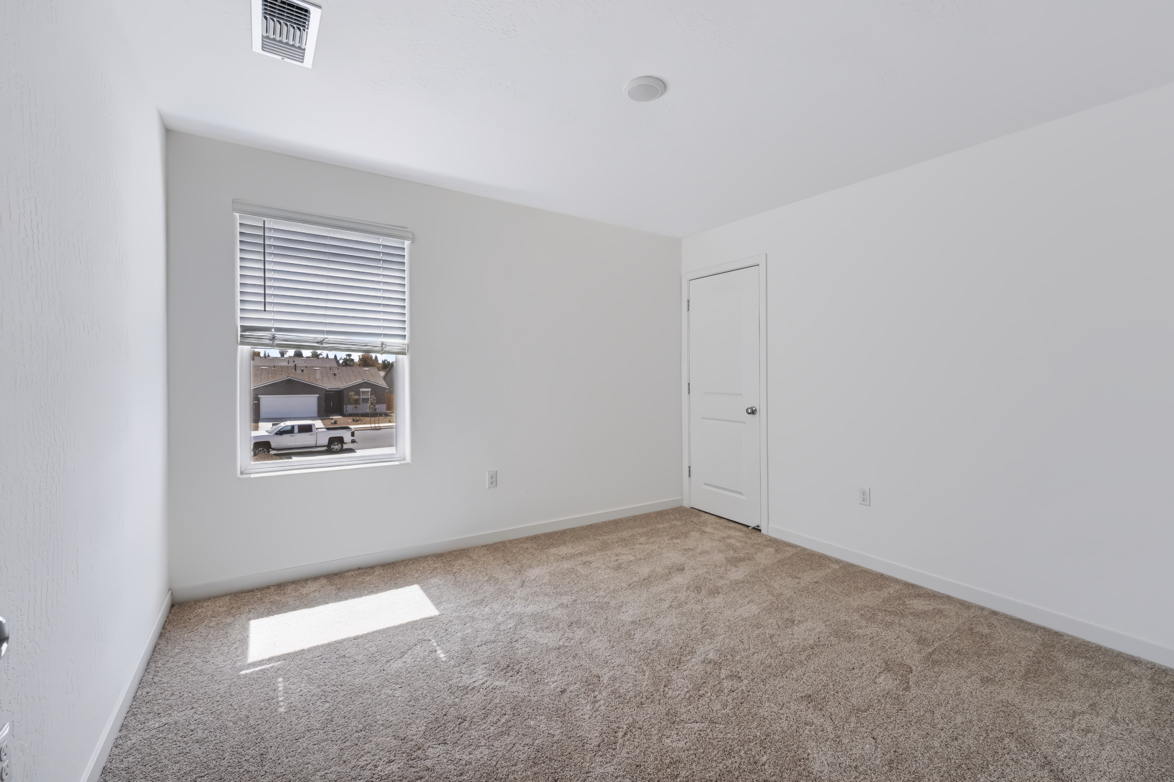A room with a window and carpet.