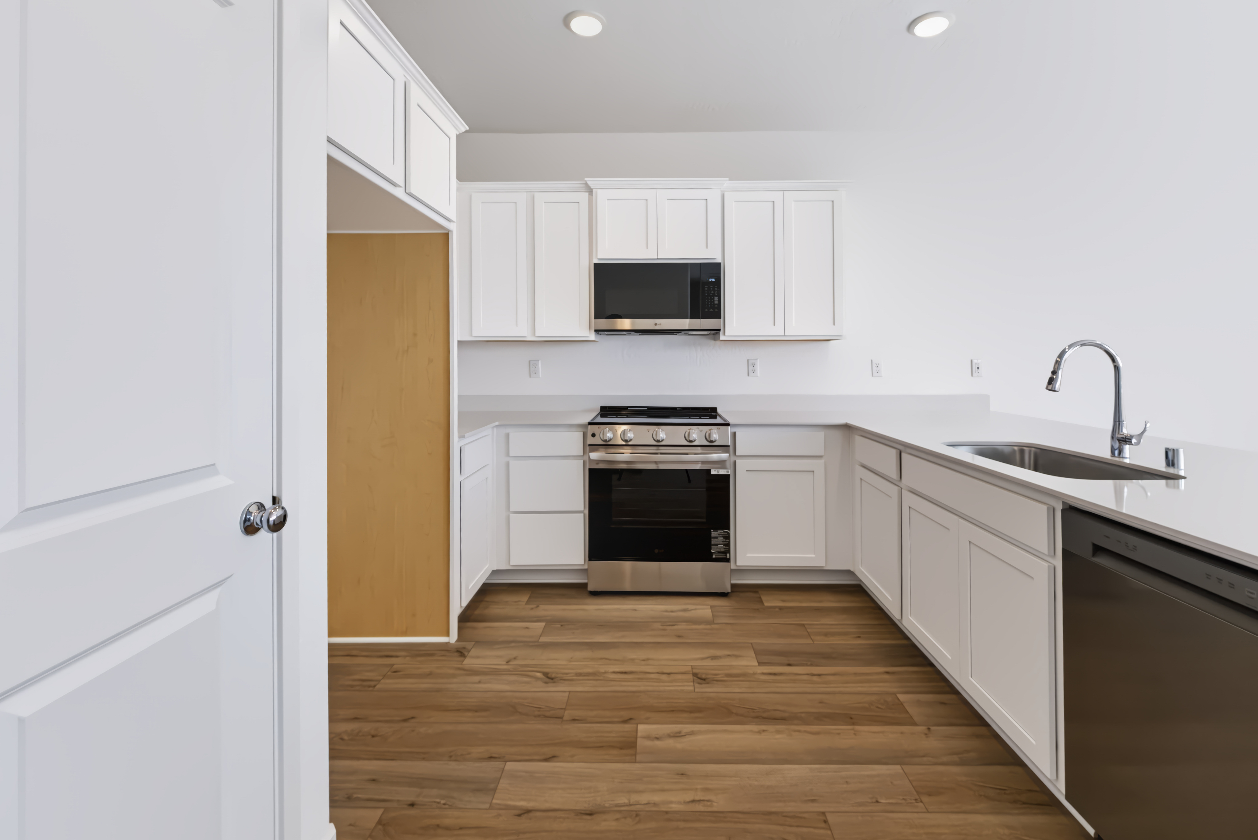 A kitchen with white cabinets.