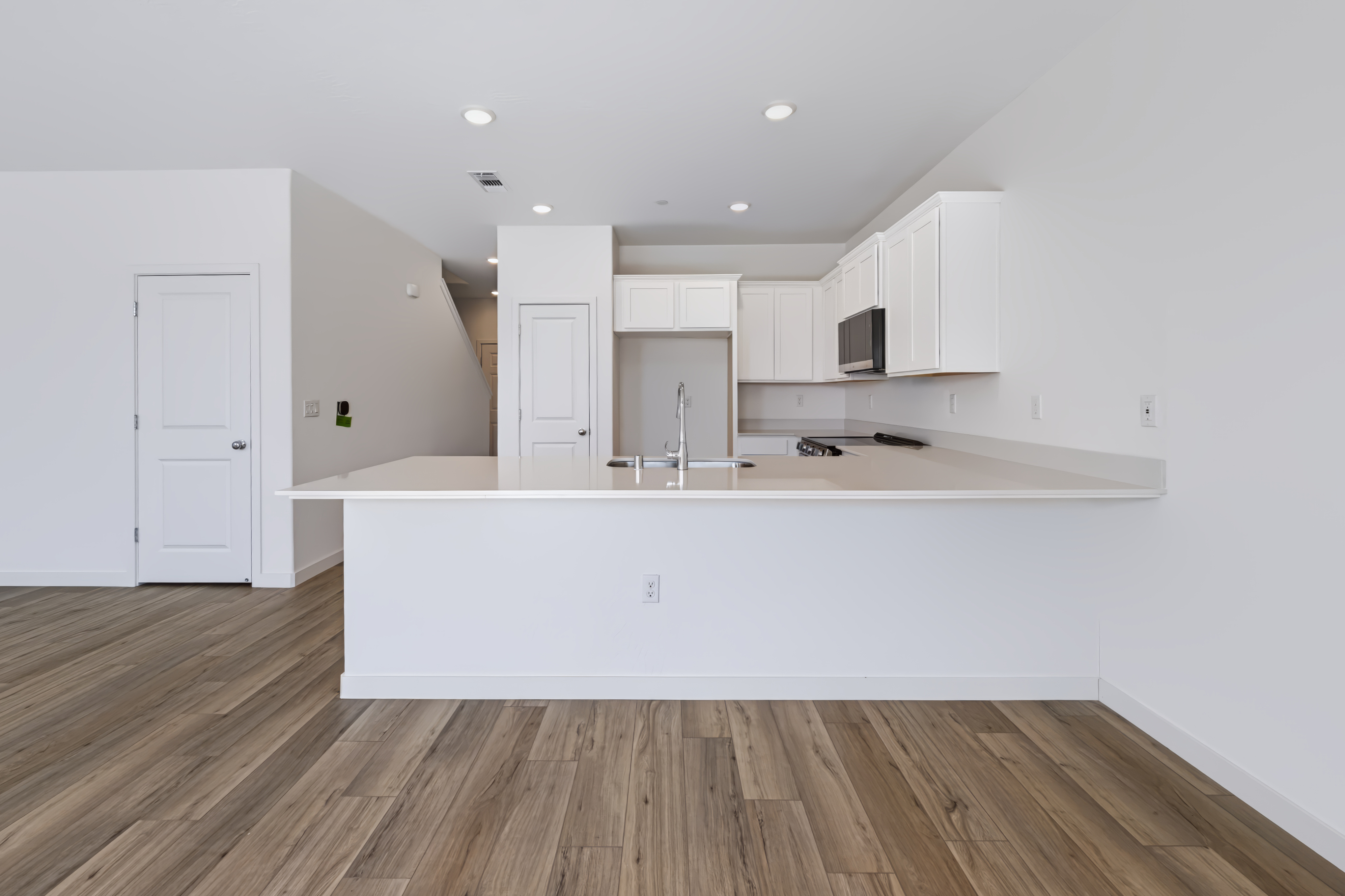 A kitchen with white cabinets.