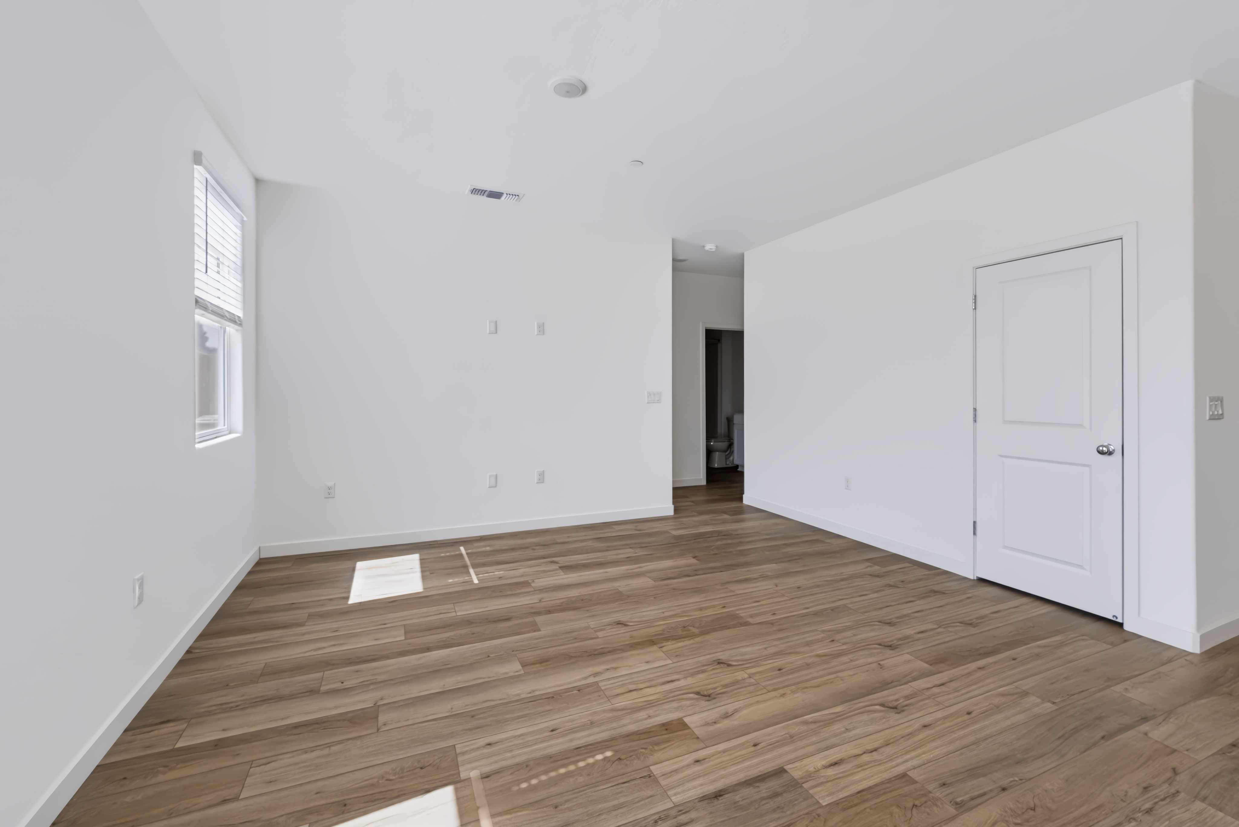 A room with white walls and wood floors.