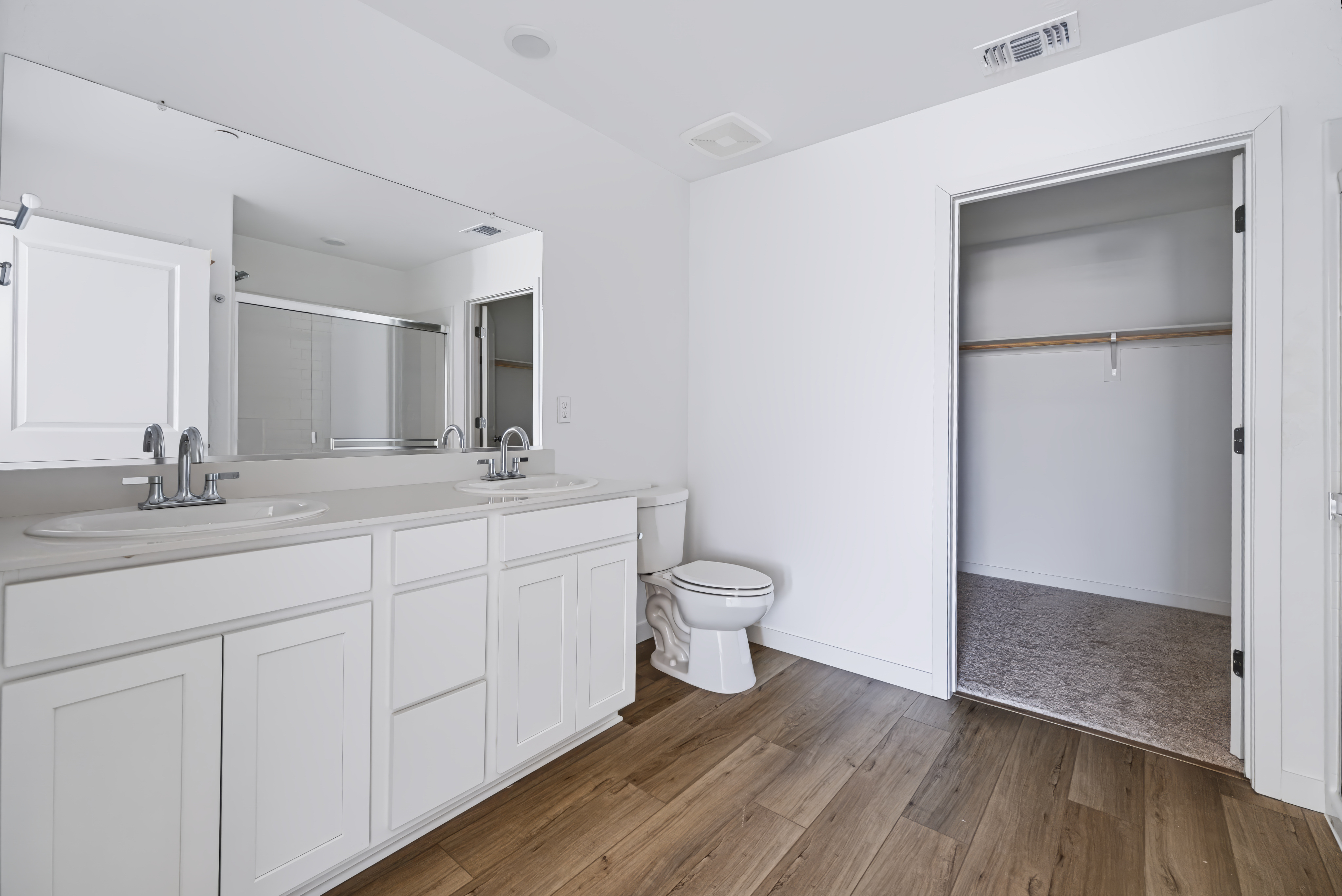 A bathroom with white cabinets.