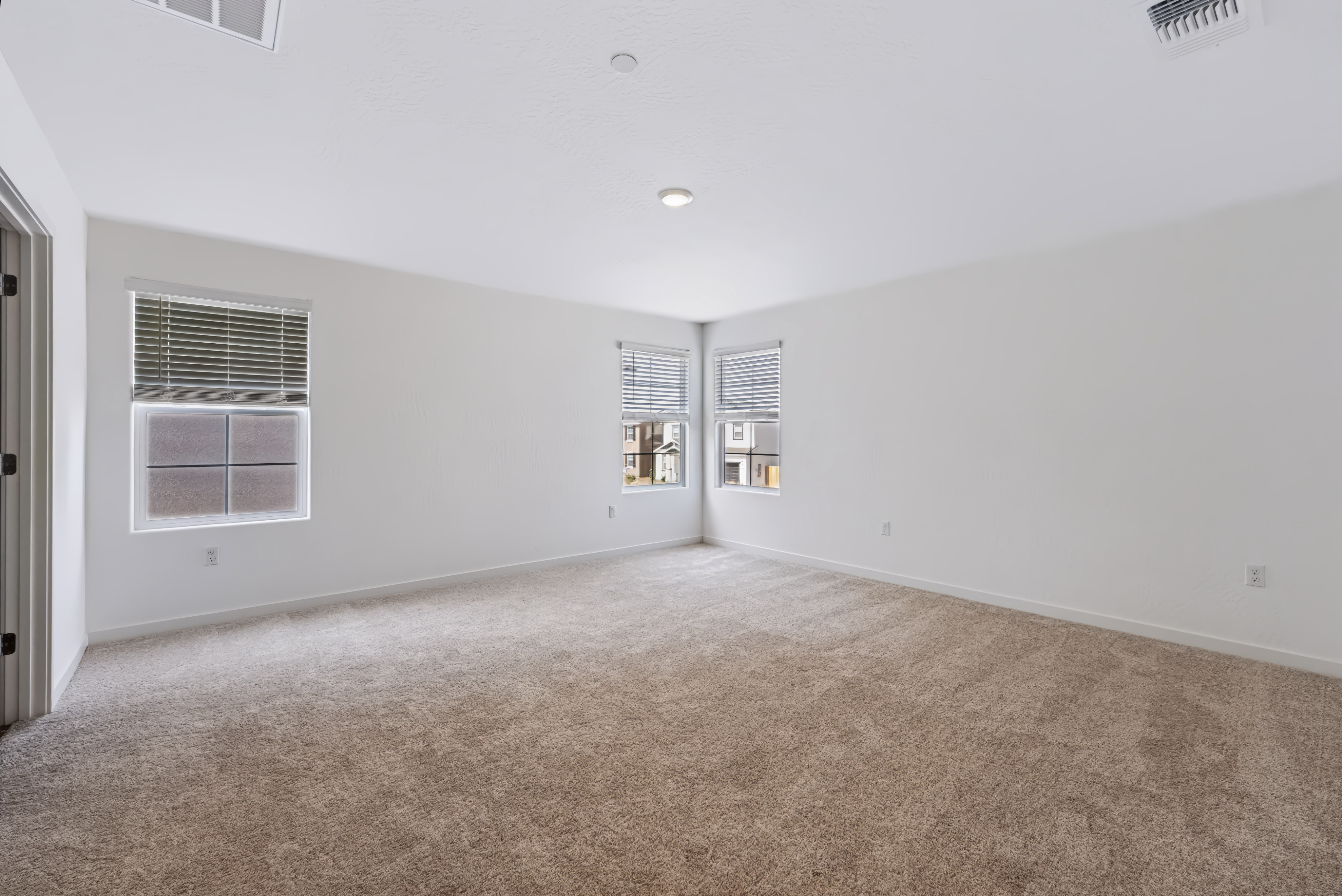 A room with a carpet and windows.