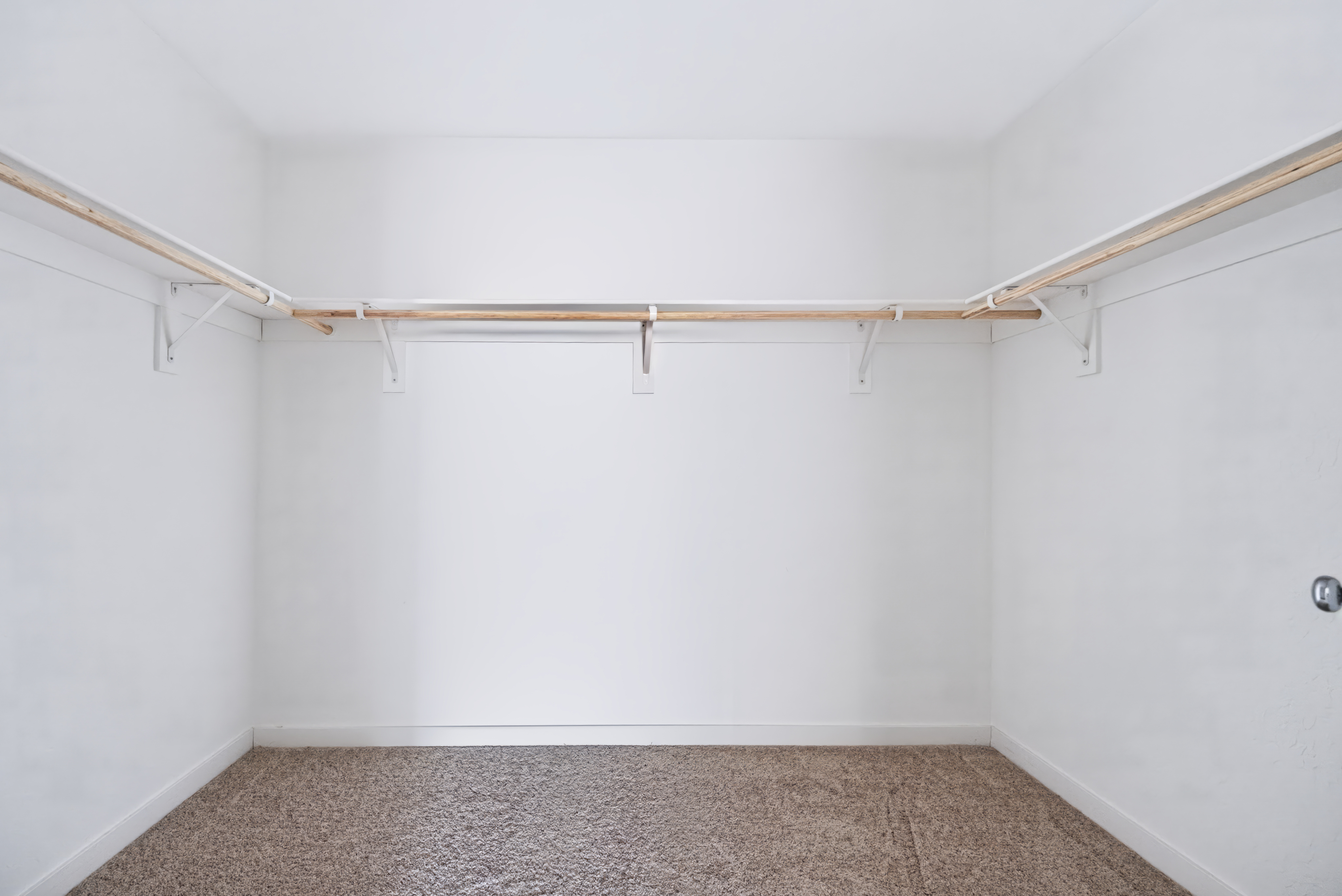 A room with a white wall and a carpet.