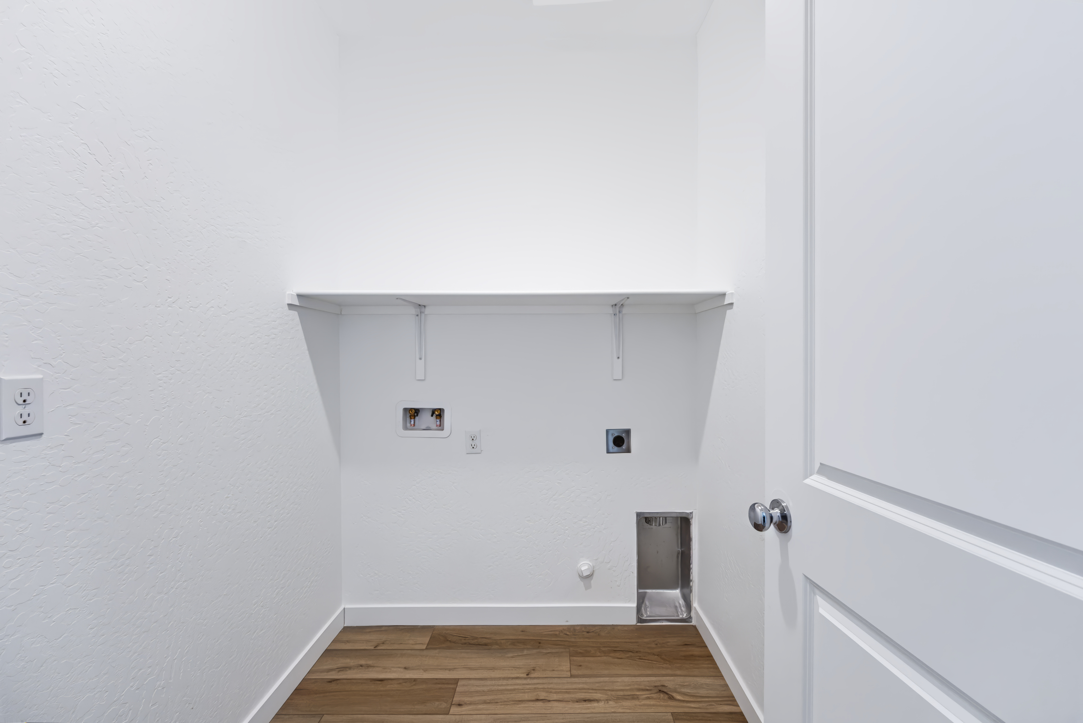 A white room with a wood floor.