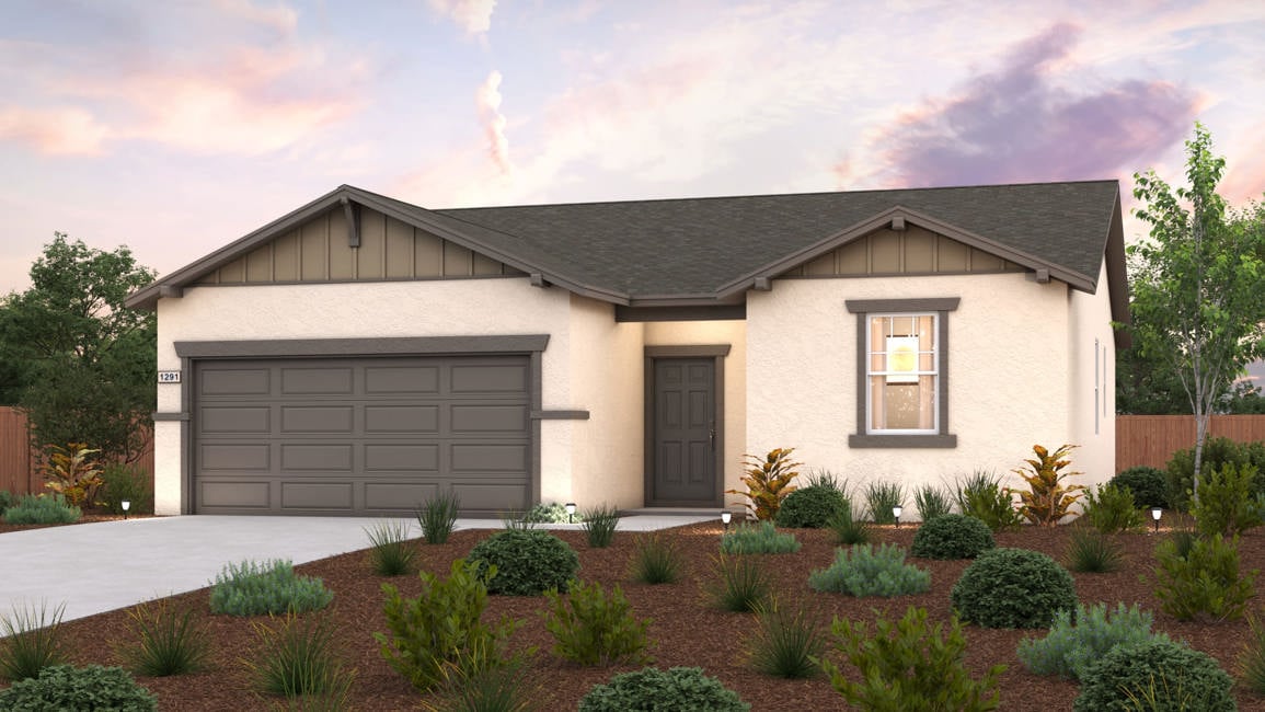 A house with a garage and bushes in front of it.