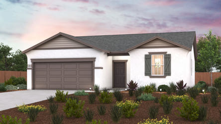 A house with a garage and bushes in front of it.