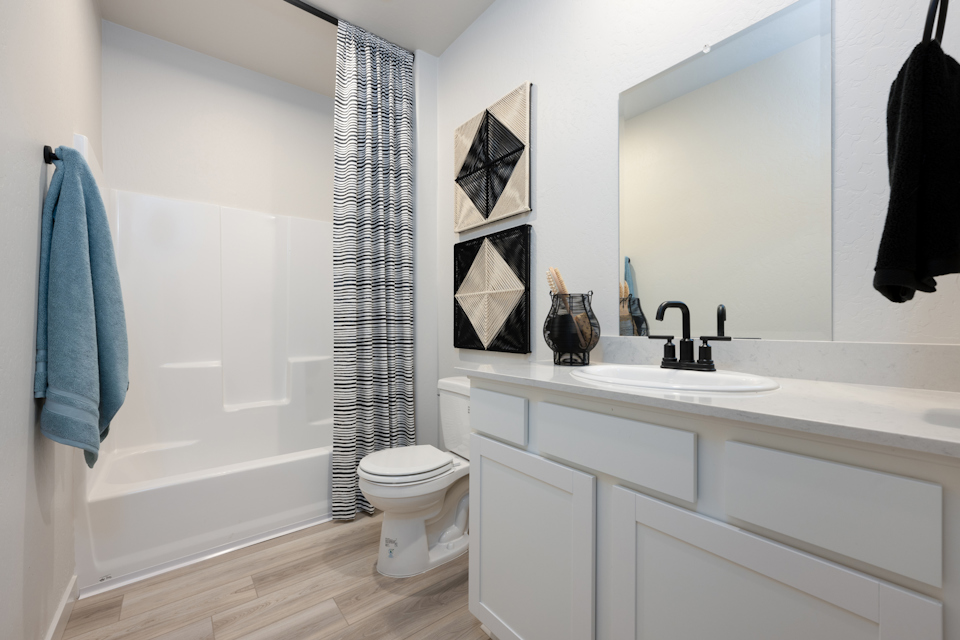 A bathroom with a tub sink and toilet.