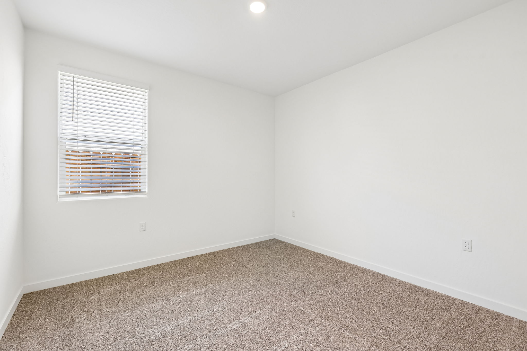 A room with a window and carpet.