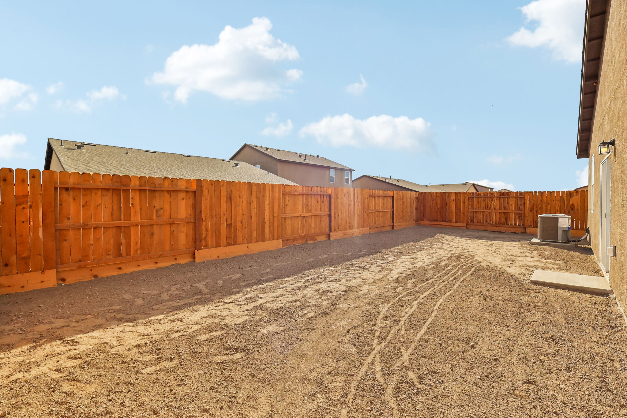 A fenced off area with a dirt road and a dirt road.