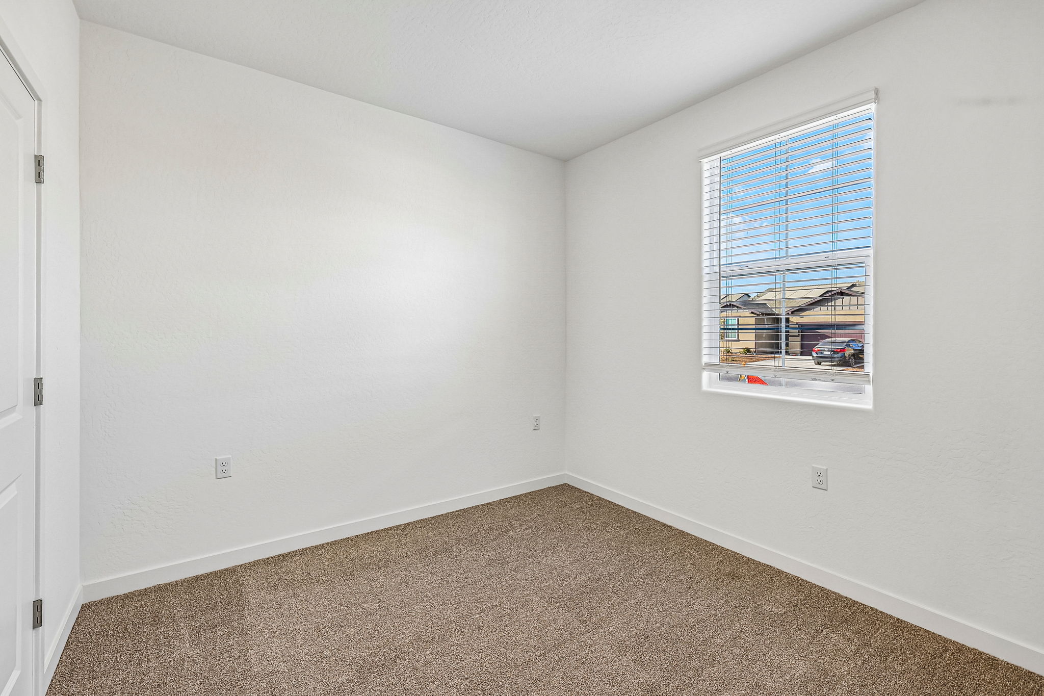 A room with a window and carpet.
