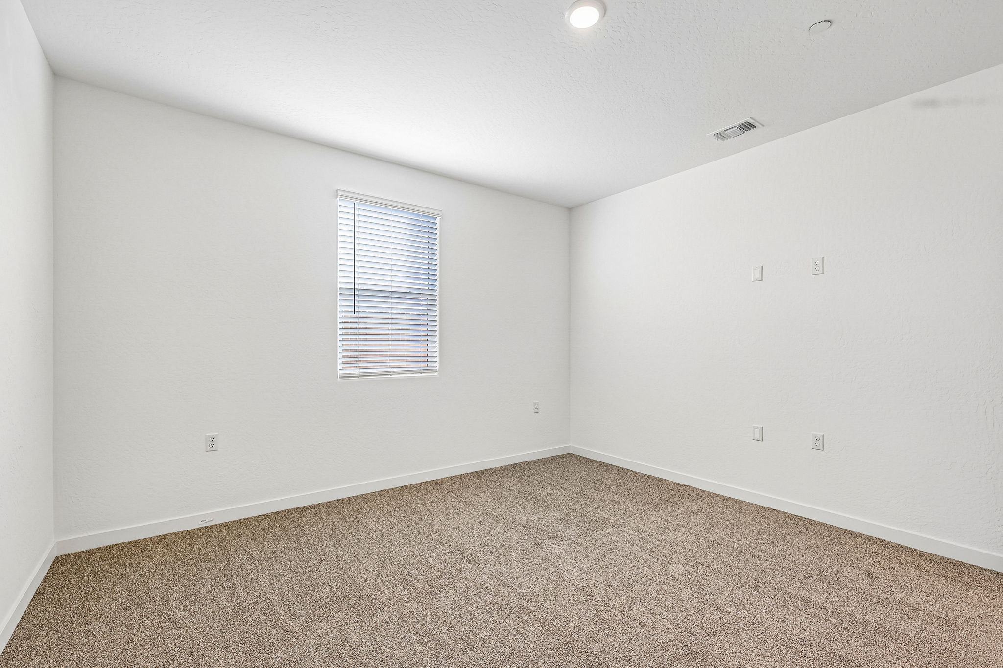 A room with a window and carpet.