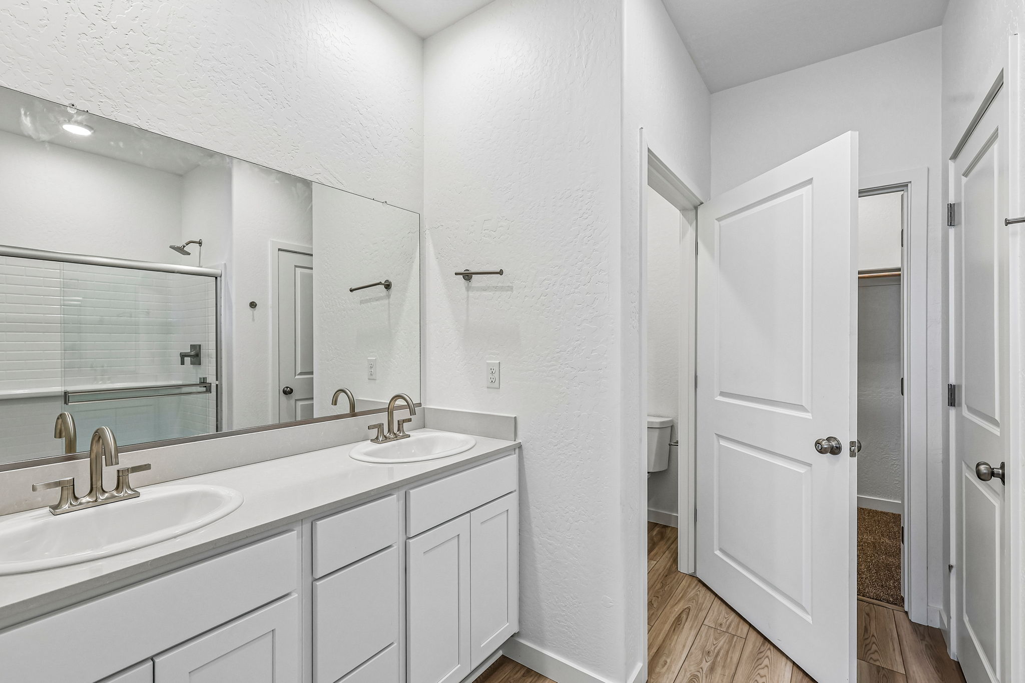 A bathroom with white cabinets.
