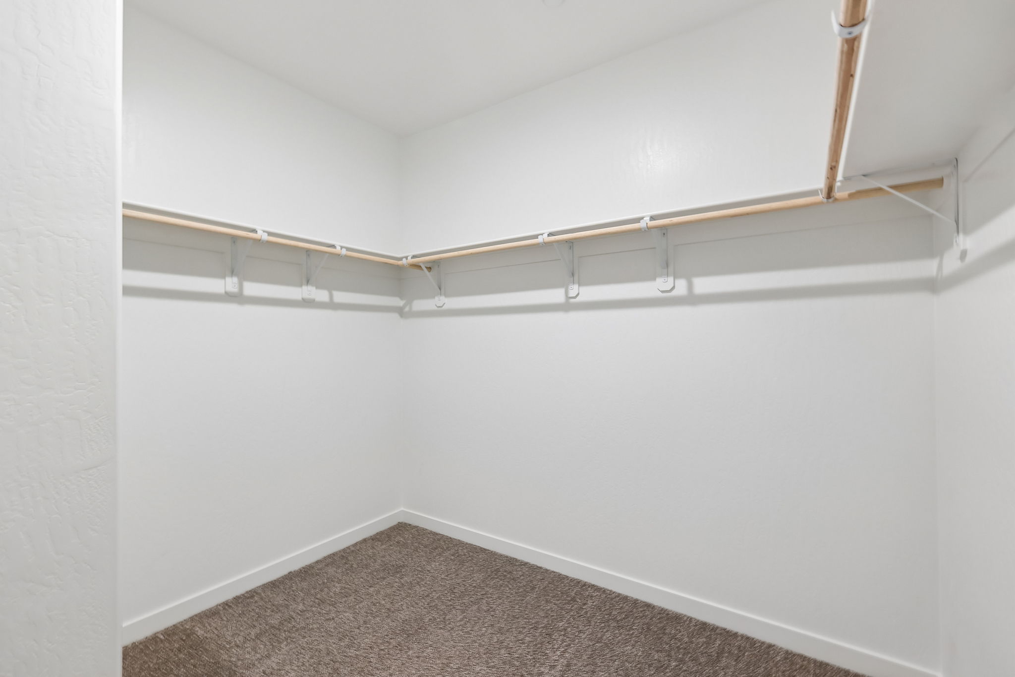 A white wall with a metal bar.